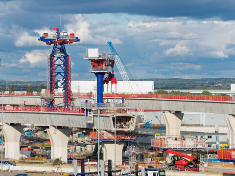 Aerial view of high speed rail construction featuring concrete pillars and specialized machinery in the United Kingdom.