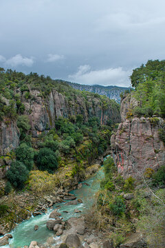 he image shows the rugged rocky cliffs and green forests of K&ouml;pr&uuml;l&uuml; Canyon National Park (specifically near Tazı Canyon) in Manavgat, Antalya, T&uuml;rkiye.