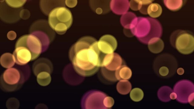 Abstract golden and pink bokeh lights floating on dark background