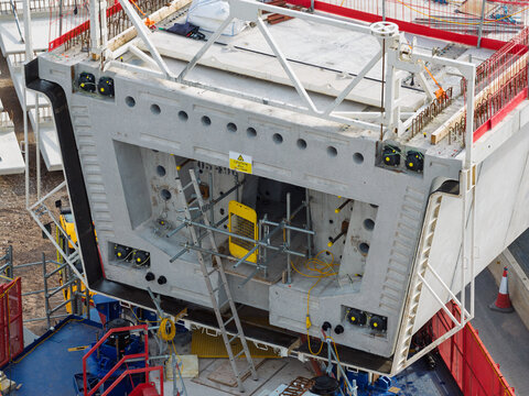 Aerial view of a large precast concrete bridge segment for high speed rail construction, featuring internal structural details, scaffolding, and safety railings in the United Kingdom.