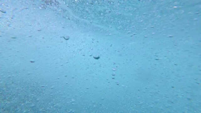 Rising bubbles underwater in clear turquoise water