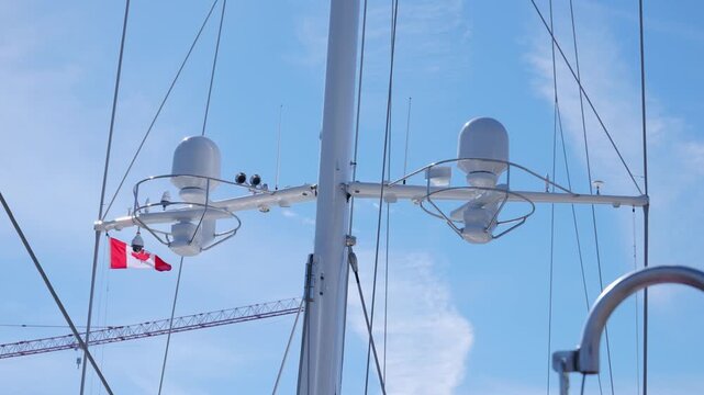 Victoria, British Columbia, Canada - October 6, 2026: Canadian flag flying from the radar mast of a modern luxury yacht