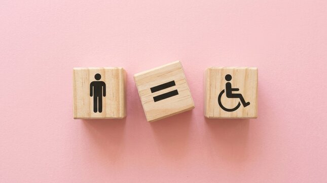 Wooden blocks with a human figure and a wheelchair symbol separated by an equals sign on a pink background, representing equality and disability rights international day of persons with disabilities