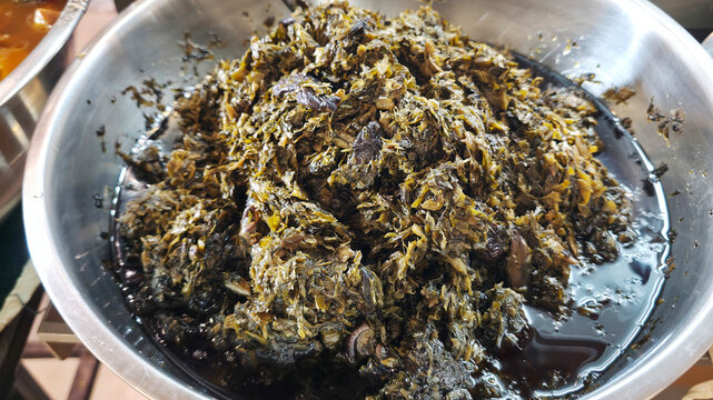Close-up of traditional Chinese olive vegetable, a preserved Teochew side dish made with pickled mustard greens and olives, featuring a savory, salty and slightly sour flavor