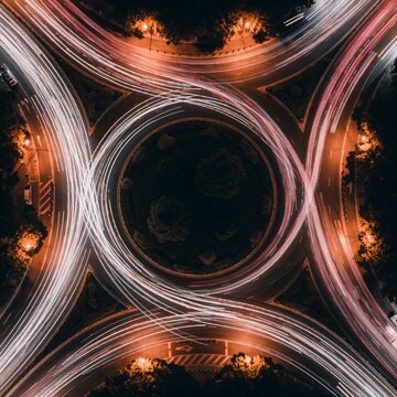 Aerial view of a traffic roundabout at night with light trails