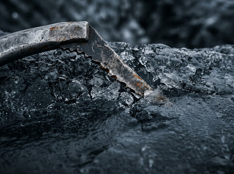sharp metal ice axe driven into clear ice in frosty outdoor close up professional climbing equipment
