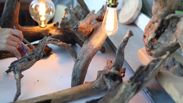A female hands applying varnish to a unique interior item made from tree roots. The beauty and uniqueness of nature in the works of a true master. Slow motion close up 4K footage.