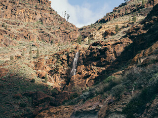 Waterfall cascades through rugged cliffs in Gran Canaria © by Natallia