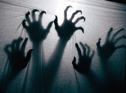  Creepy silhouette of ghost hands scratching transparent plastic film horror art
