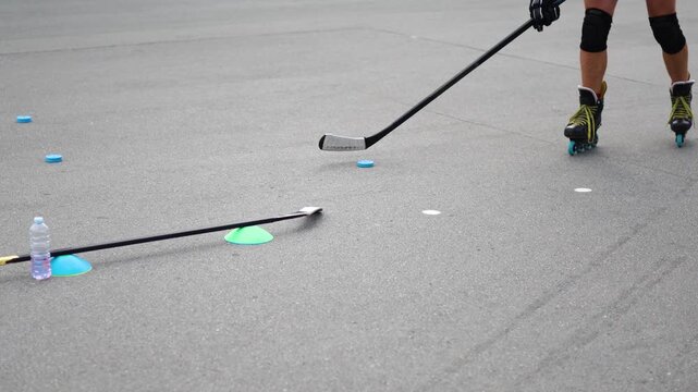 A detailed view of a middle-aged man's legs executing roller skating techniques, highlighting his commitment as he performs on a smooth asphalt surface. Close-up slow motion 4k footage.