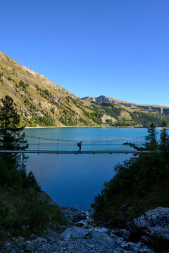Silhouette of a man crossing a suspension bridge over Lake Tzeusier, Switzerland