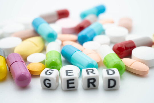 GERD Gastro esophageal Reflux Disease word with pills and capsules medical drug.