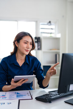 Woman, reading and point at computer screen in office for business strategy, planning and thinking.