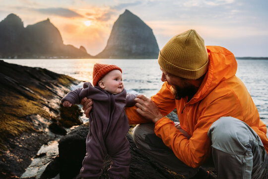Father and baby playing together by the sea in Norway family travel lifestyle with infant, candid emotions parent with kid explore Helgeland islands autumn vacations outdoor care bonding Fathers Day