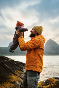 Happy dad lifting infant baby playing together outdoors enjoying autumn holidays family lifestyle, bonding fatherhood childhood care father and kid travel in Norway candid emotions, Fathers day