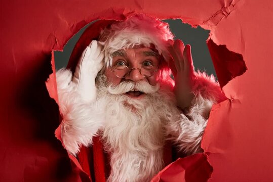 A cheerful Santa Claus with his iconic white beard and red suit peeks through a tear in vibrant red paper, his eyes sparkling with festive mirth.