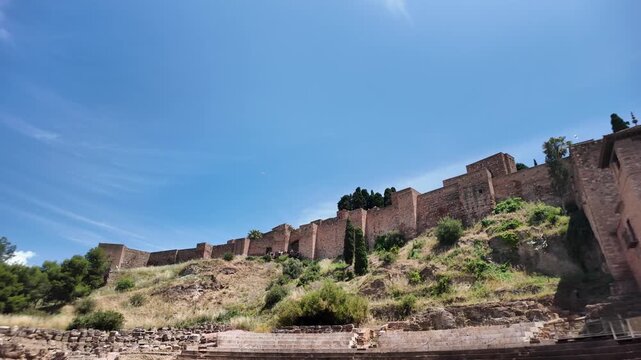Roman Theatre in Malaga (Teatro Romano de M&aacute;laga) set against the fortified walls of the Moorish Alcazaba fortress in Andalusia, southern Spain.