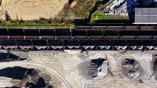 Aerial view of a long freight train loaded with gravel at the Dolomitas industrial quarry site in Petrasiunai, Siauliu apskritis, Lithuania.