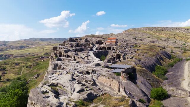 Uplistsikhe Ancient Rock-hewn Town Carved Into A High Cliff Above The Mtkvari River In Eastern Georgia. Aerial Drone Shot