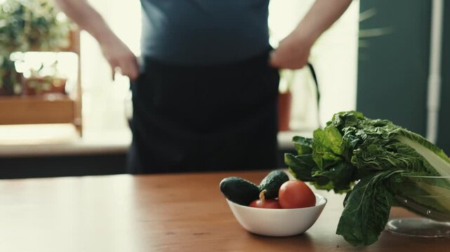 Close Up of Chef Tying Black Apron Strings Before Cooking in Kitchen