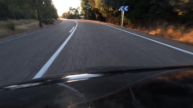 POV Driving Into Blinding Sunset on Curving Rural Road