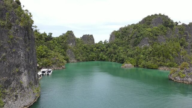 Aerial view of the lush green karst islands of Piaynemo rising from the turquoise waters in Raja Ampat, Southwest Papua, Indonesia.