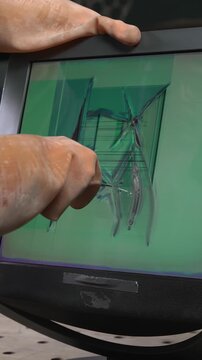 Mechanical impact on the monitor's LCD screen using a punch or similar tool, resulting in pixel damage and cracks.