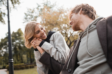 Fototapeta premium Happy young couple enjoys a romantic date while holding hands in an autumn park