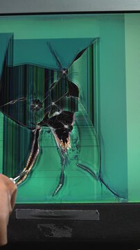 Mechanical impact on the monitor's LCD screen using a punch or similar tool, resulting in pixel damage and cracks.