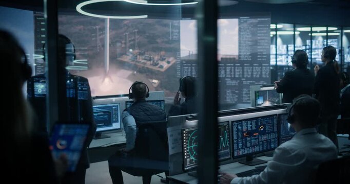 Monitoring Control Room: Flight Specialists Analyze Telemetry Dashboards and Live Launch Feeds While a Reusable Rocket Booster Fires Its Engines and Lands Safely, Sparking Applause and Celebration.