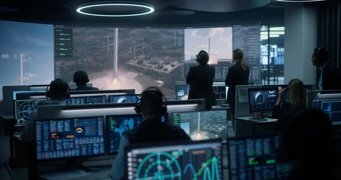 Monitoring Control Room: Diverse Engineers in Headsets Track Telemetry on Glowing Screens as a Reusable Rocket Booster Touches Down on the Landing Pad, Then Applaud and Shake Hands in Celebration.