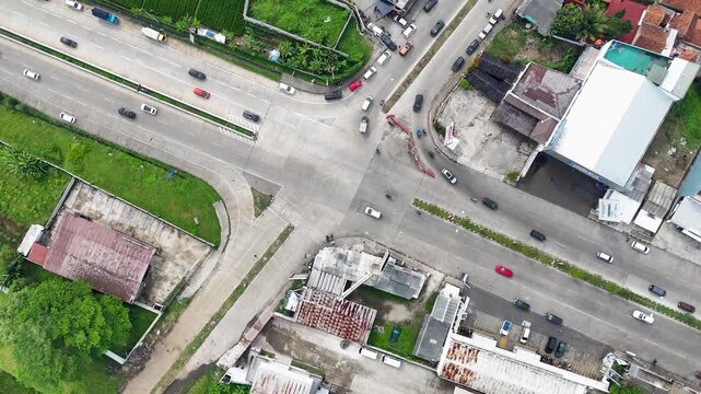 Aerial view of a busy road intersection in Soreang with surrounding buildings and lush greenery in Bandung, West Java, Indonesia.