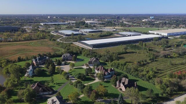 Aerial view of a large industrial data center surrounded by residential houses, green lawns, and trees in Hoffman Estates, Illinois, United States.