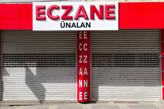 Turkey, Istanbul, September 5, 2026. Eczane Unalan storefront with closed shutters on a quiet street in the daytime