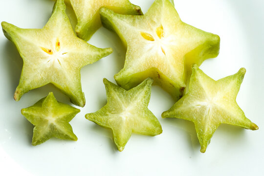 Fresh star fruit slices arranged on clean white background