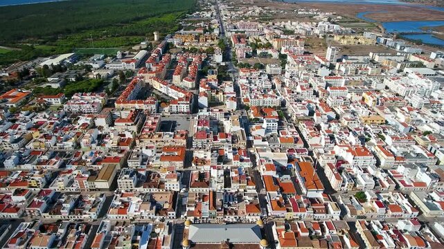Aerial drone footage revealing the distinctive grid like urban planning of vila real de santo antonio in the algarve region, portugal, highlighting its traditional architecture and coastal setting