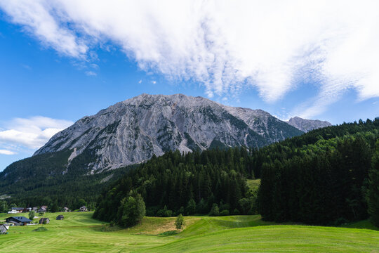 Grimming mountain above green meadows and forest in Austria