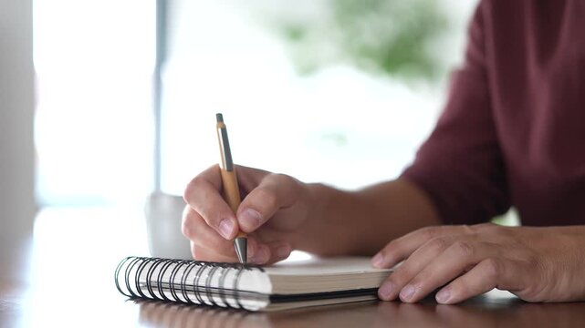 Male hands writing notes in a notebook