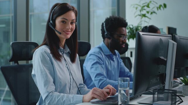 Positive Caucasian busines woman working in call center smiling looking at camera optimistic businesswoman talking in support customer service three multiethnic business workers team work at helpline