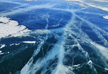 A winter landscape of frozen Lake Baikal in Siberia with deep blue ice and natural cracks. Scenic nature view of frozen water.  © Viks_jin