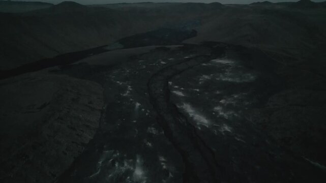 Aerial view of dark volcanic lava fields and rugged terrain in Iceland.