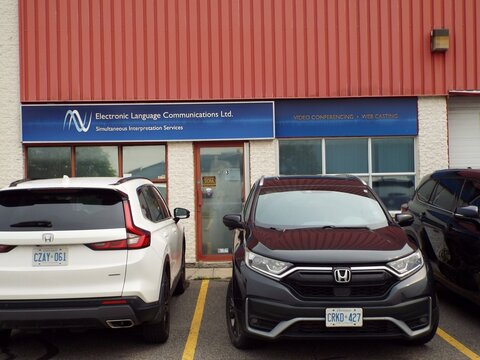 Gloucester, Ontario, Canada &ndash; July 31, 2026: The exterior of a commercial building features a sign for "Electronic Language Communications Ltd. Simultaneous Interpretation Services" and windows at 551