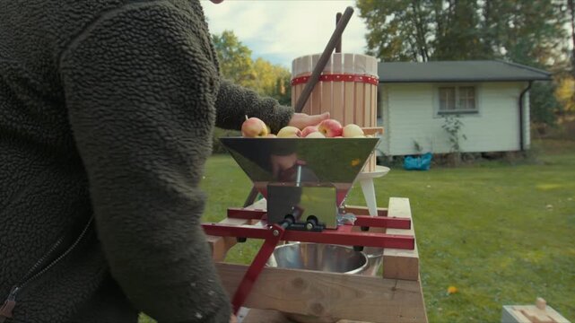 Woman press apple juice in garden