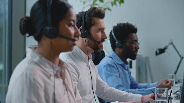 Indian business woman Arabian female with diverse call center operators team wearing headsets talking handling client requests communication work at telephone support in callcenter hotline service