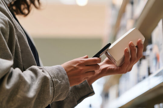 A shopper is examining a product while using a smartphone to scan its barcode, showcasing the integration of technology in retail shopping experiences.