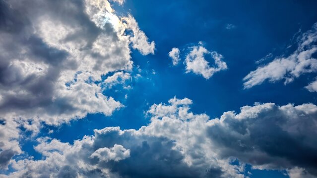 Dramatic blue sky with fluffy white clouds and bright sunlight background