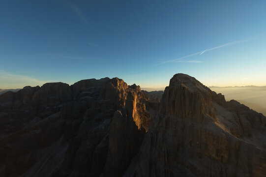 Vista aerea all'alba sulle cime e delle Dolomiti di Brenta con foschia nella valle