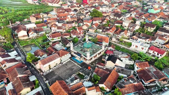 Aerial view of the mosque surrounded by dense residential rooftops and lush greenery in Ciwidey, Bandung, West Java, Indonesia.