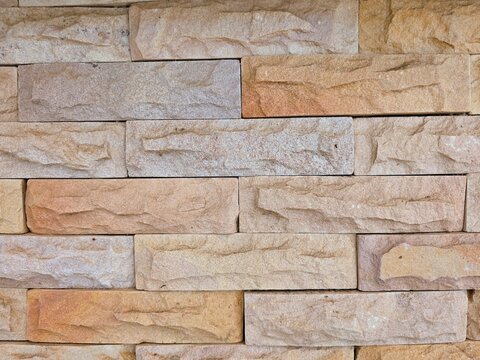 Modern sandstone brick wall texture background, decorative stone tile cladding for interior and exterior architecture design.
