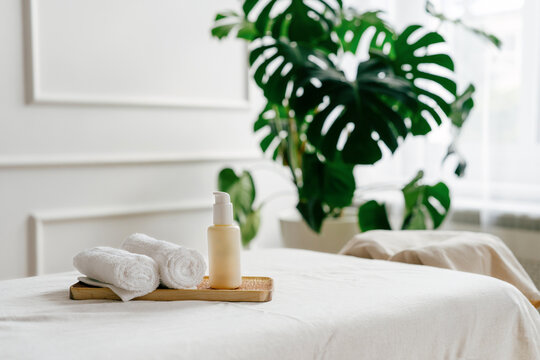 Spa treatment room with folded towels and lotion bottle on table
